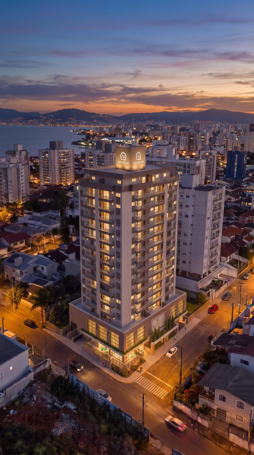 Vistage Residence iluminado ao pôr do sol, com a baía da Grande Florianópolis ao fundo