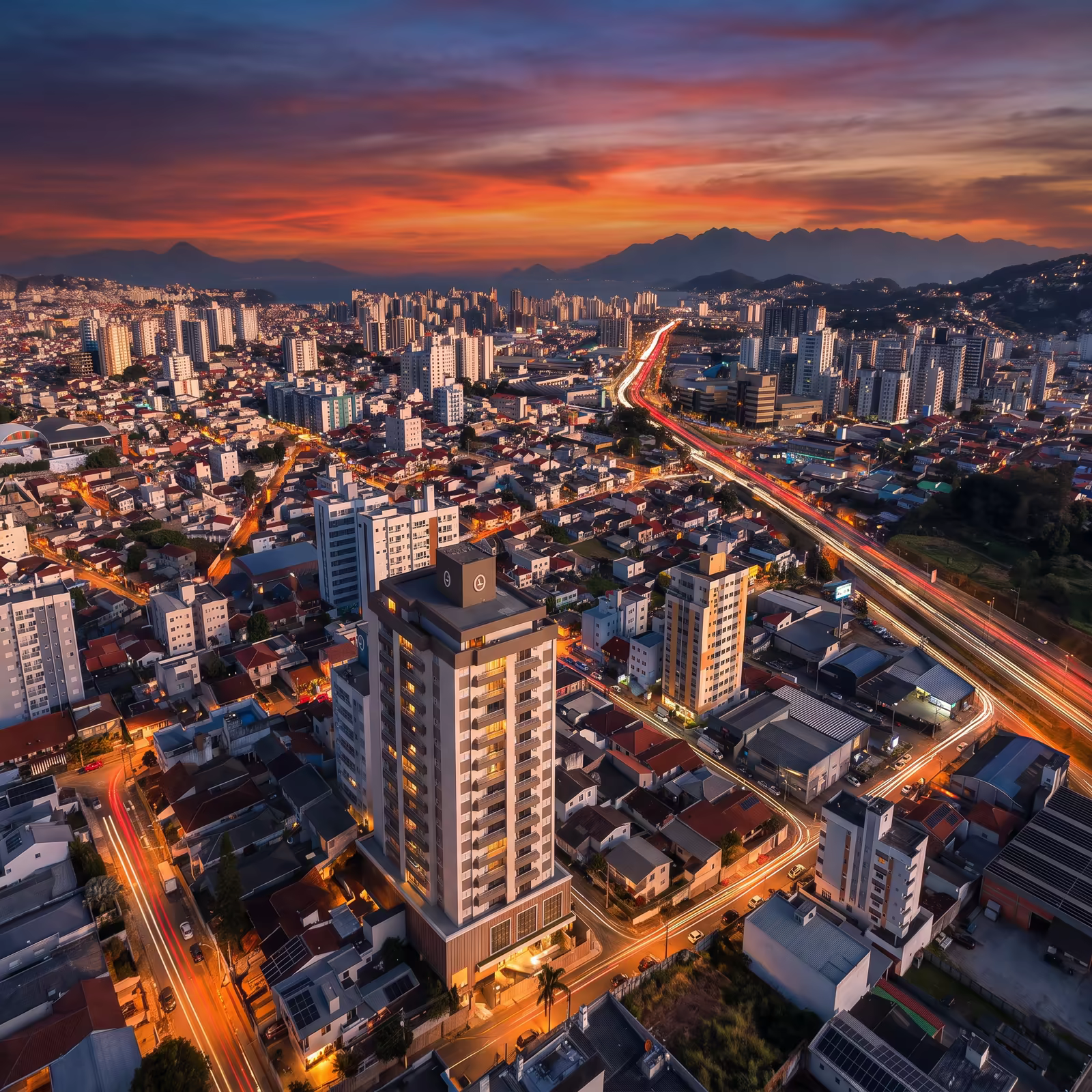 Vista aérea do Vistage Residence ao pôr do sol, com a Grande Florianópolis ao fundo